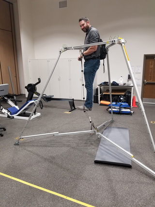 NASA scientist Jason Norcross climbs a ladder within a framework of lightweight metal tubing that simulates the outline of a space capsule. NASA seeks to gauge how readily an astronaut who has just returned to Earth can climb through this capsule.

